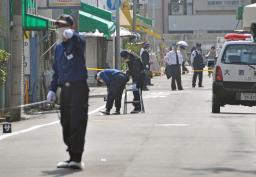 男女が刃物で刺された現場付近を調べる大阪府警の捜査員=22日午前9時5分、大阪市生野区
