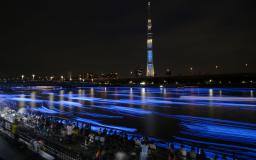　青く光るＬＥＤをホタルに見立て、隅田川に流すイベント「東京ホタル」。奥は東京スカイツリー＝２５日夜、東京都台東区（３０秒間露光）