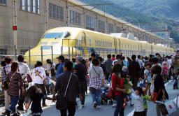 JR西日本が初めて一般公開したドクターイエローと見学者=19日、福岡県那珂川町の博多総合車両所