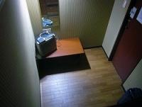 寝台の上から眺めた1・7畳の空間。小さなテレビと机、鏡だけが備えられていた。電灯は暗く、長時間本を読むのも難しい=東京都中野区で
